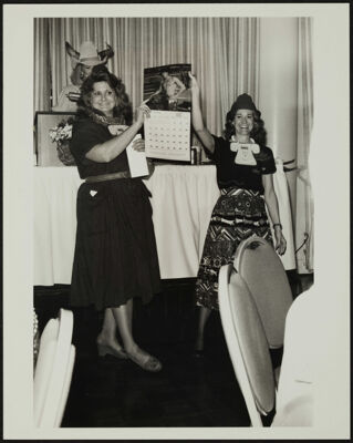 Two Rodeo Committee Members Holding a Calendar Photograph