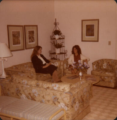 unidentified epsilon tau chapter member on patterned couch photograph, c. 1977 (image)