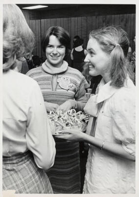 unidentified epsilon tau chapter member on patterned couch photograph, c. 1977 (image)