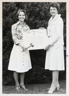 unidentified epsilon tau chapter member on patterned couch photograph, c. 1977 (image)