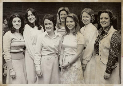 unidentified epsilon tau chapter member on patterned couch photograph, c. 1977 (image)