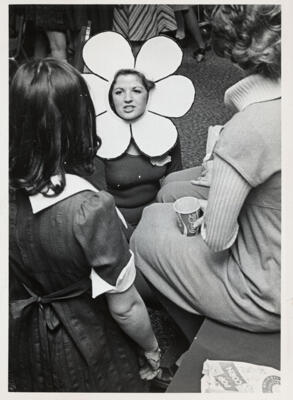 unidentified epsilon tau chapter member on patterned couch photograph, c. 1977 (image)