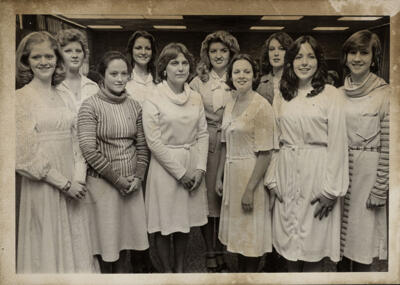 unidentified epsilon tau chapter member on patterned couch photograph, c. 1977 (image)