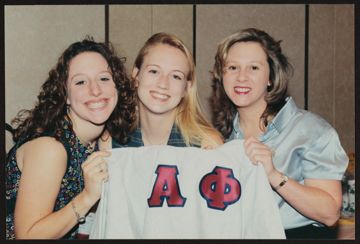 Three Alpha Phis Holding Shirt in Phi Market Photograph, 1990s