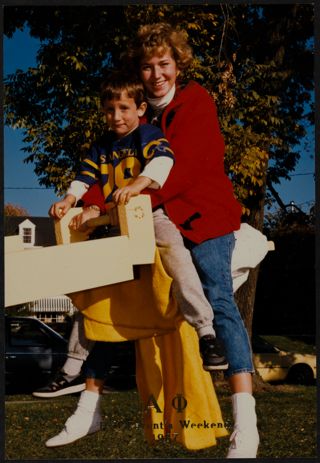 Unidentified Gamma Chapter Member and Child at Parent's Day Weekend Photograph, 1987