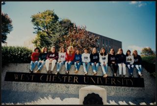 Epsilon Kappa Members Sitting on West Chester University Sign Photograph, c. 1994