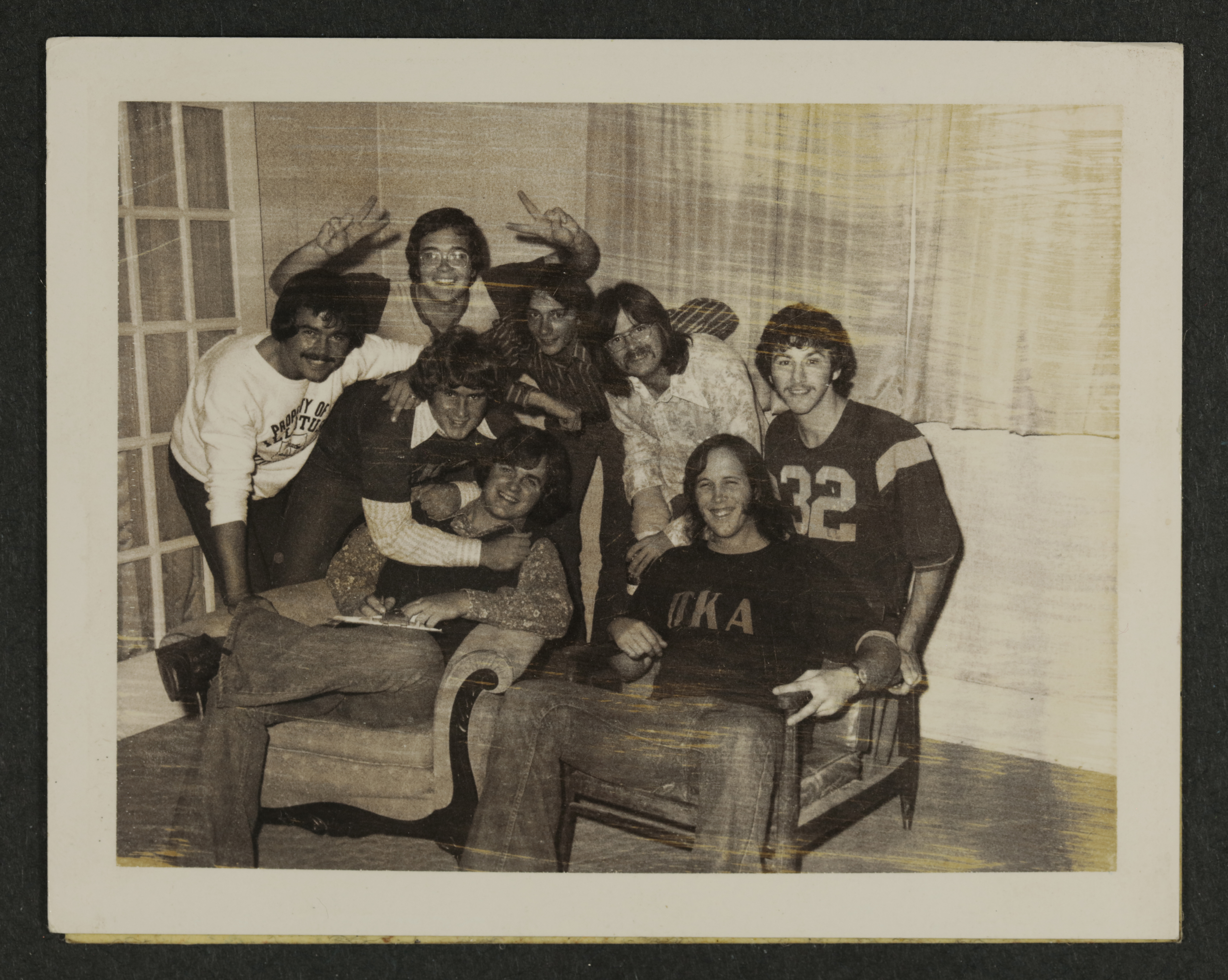 Eight Eta Psi Chapter Members in Living Room Photograph, c. 1973-1982