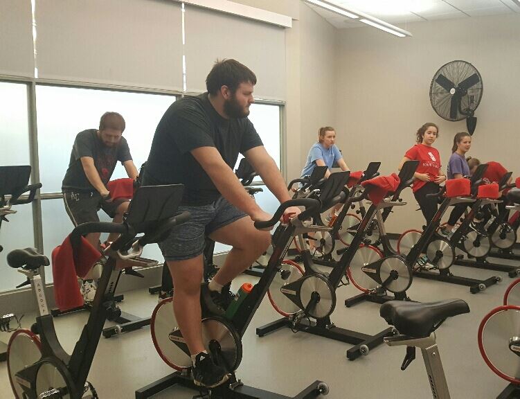 Unidentified Pikes and College Students Ride Stationary Bikes Photograph