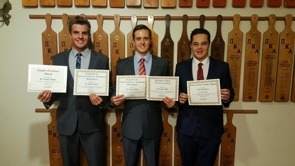 Three Zeta Rho Chapter Members Hold Up Awards Photograph