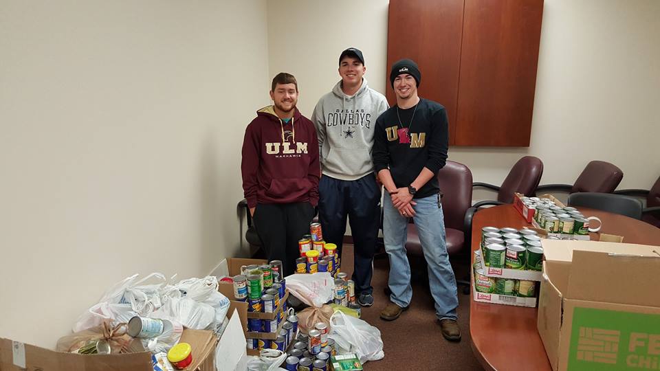 Three Eta Omicron Chapter Members Collecting Canned Goods Photograph