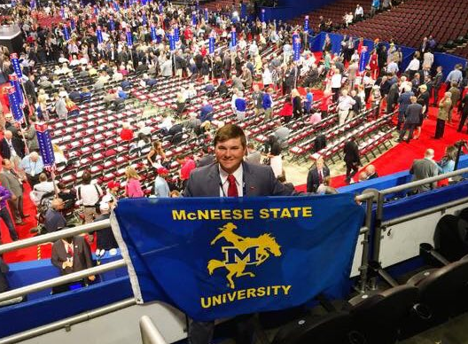 Lambda Upsilon Chapter Member Holding a McNeese State Flag Photograph