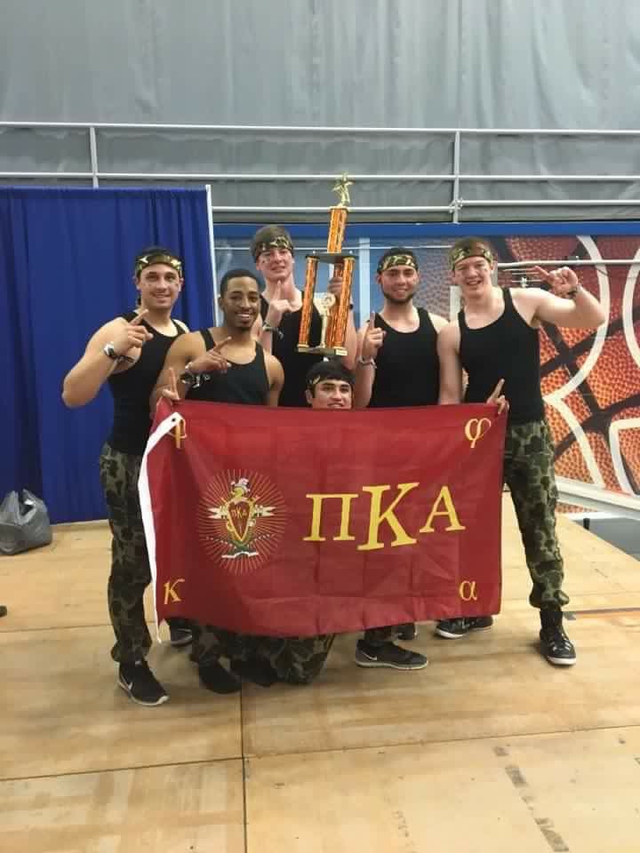 Six Zeta Gamma Chapter Members with a Trophy and a PiKA Flag Photograph