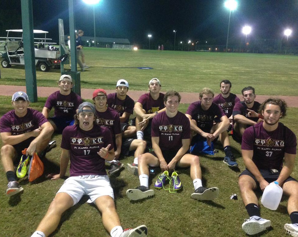 Iota Upsilon Chapter Members Sit on an Athletic Field Photograph