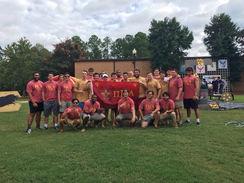 Mu Iota Chapter Members Take a Picture with the PiKA Flag Photograph
