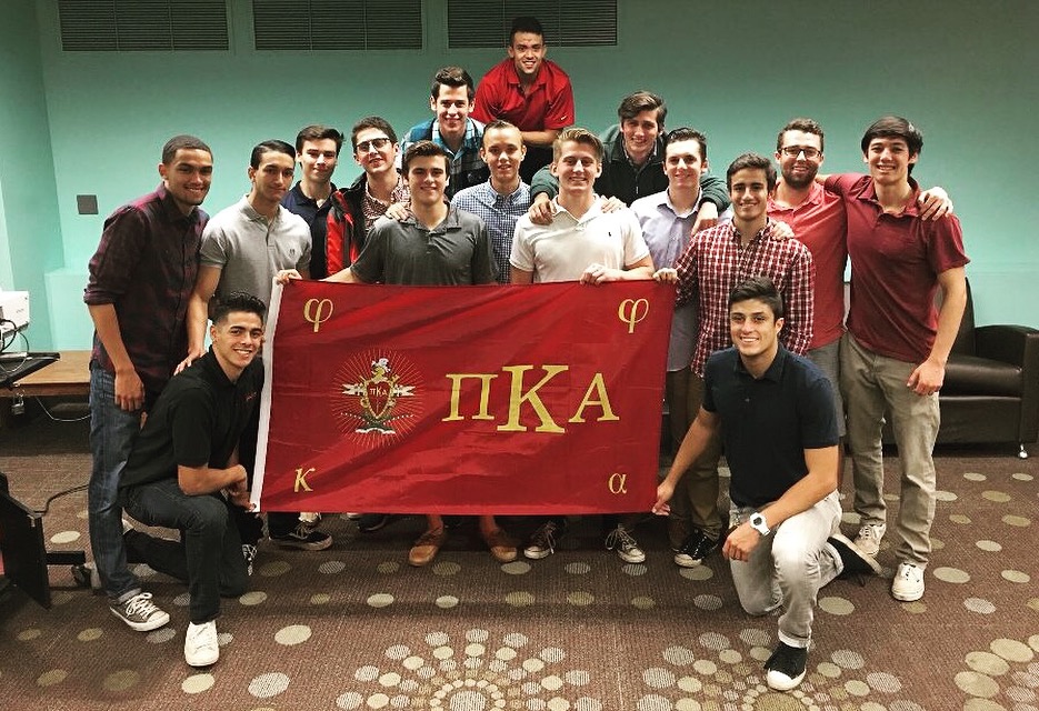 Lambda Psi Chapter Members with a Pi Kappa Alpha Flag Photograph
