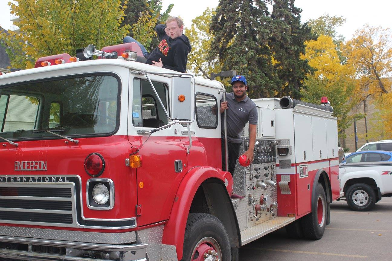 Two Lambda Epsilon Chapter Members On a Fire Truck Photograph