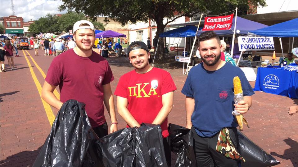 Three Theta Xi Chapter Members Carry Trash Bags Photograph