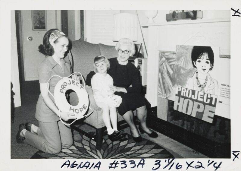 Phi Mus and Child with Project HOPE Poster and Lifesaver Photograph, 1971 (Image)