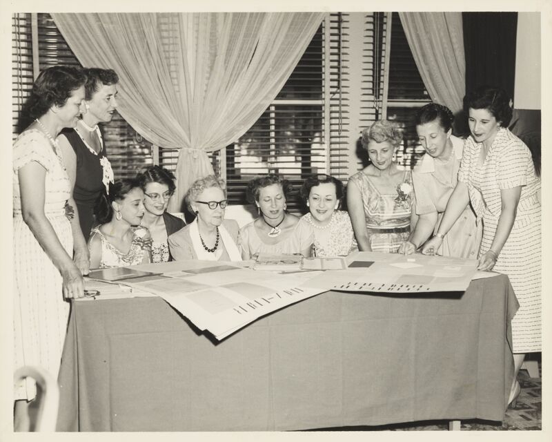 Edgewater Convention Group Looking at Posters Photograph, 1956 (Image)