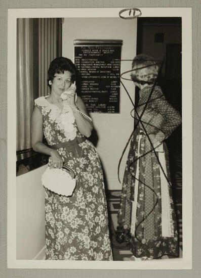 Patricia Cramer and Ann Byrd Using Telephone at Convention Photograph, August 2-7, 1974 (image)