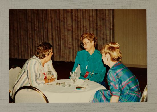 Three Phi Mus at Table During Convention Photograph, July 6-10, 1986 (image)