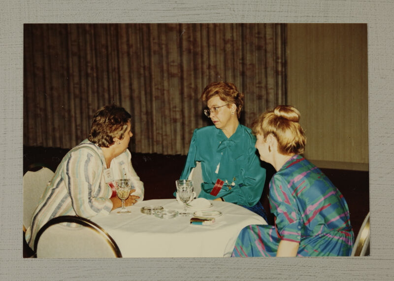 Three Phi Mus at Table During Convention Photograph, July 6-10, 1986 (Image)