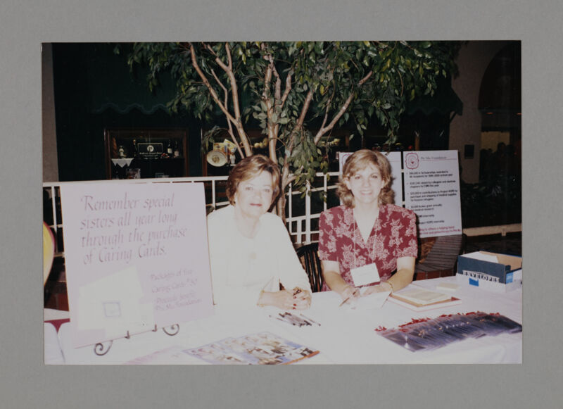 Two Phi Mus at Caring Cards Table at Convention Photograph, July 3-5, 1998 (Image)