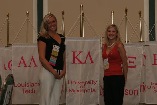 Katie Lyons and Katie Henderson by Kappa Lambda Chapter Flag at Convention Photograph, July 2006 (image)