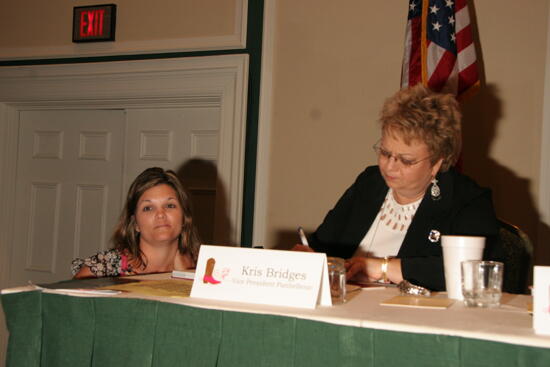 Kathy Williams Signing Book for Unidentified Phi Mu at Convention Sisterhood Luncheon Photograph, July 15, 2006 (image)