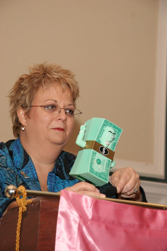 Kathy Williams With Dollar Bill Action Figure at Thursday Convention Session Photograph 2, July 13, 2006 (Image)