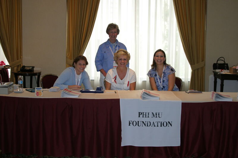 Stone, Garland, and Two Phi Mus at Foundation Table During Convention Photograph, July 8-11, 2004 (Image)