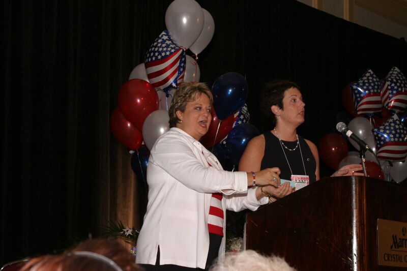 Kathy Williams and Jen Wooley Speaking at Convention Red, White, and Phi Mu Dinner Photograph, July 8, 2004 (Image)