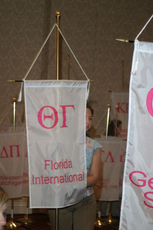 Unidentified Phi Mu With Theta Gamma Chapter Banner in Convention Parade of Flags Photograph, July 9, 2004 (Image)