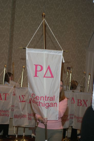 Unidentified Phi Mu With Rho Delta Chapter Banner in Convention Parade of Flags Photograph, July 9, 2004 (image)