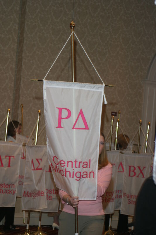 Unidentified Phi Mu With Rho Delta Chapter Banner in Convention Parade of Flags Photograph, July 9, 2004 (Image)