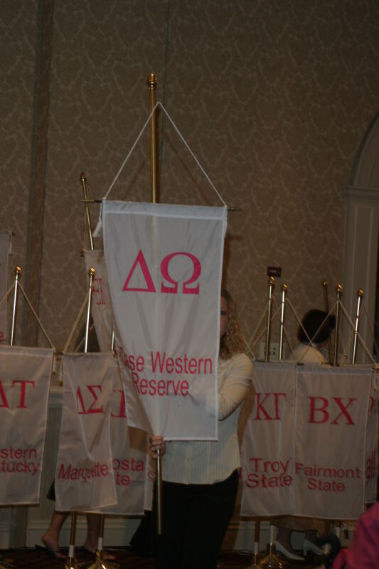 Unidentified Phi Mu With Delta Omega Chapter Banner in Convention Parade of Flags Photograph, July 9, 2004 (Image)