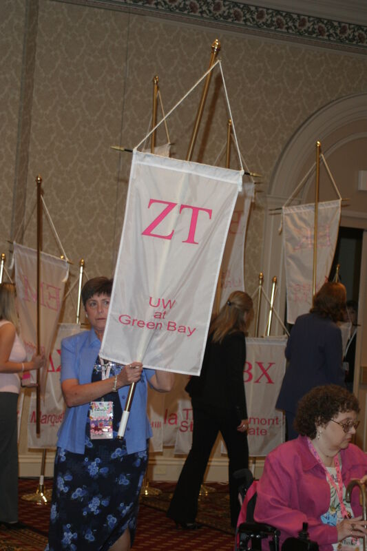 Unidentified Phi Mu With Zeta Tau Chapter Banner in Convention Parade of Flags Photograph, July 9, 2004 (Image)