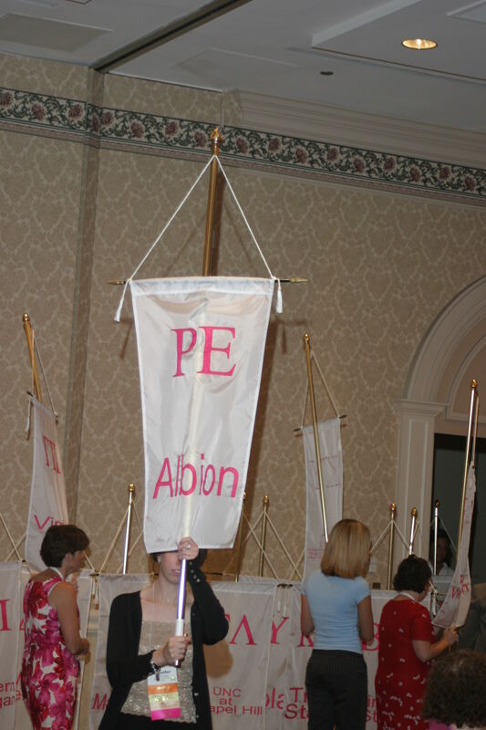 Unidentified Phi Mu With Rho Epsilon Chapter Banner in Convention Parade of Flags Photograph, July 9, 2004 (Image)