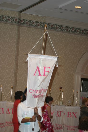 Carlina Figueroa With Lambda Epsilon Chapter Banner in Convention Parade of Flags Photograph, July 9, 2004 (image)