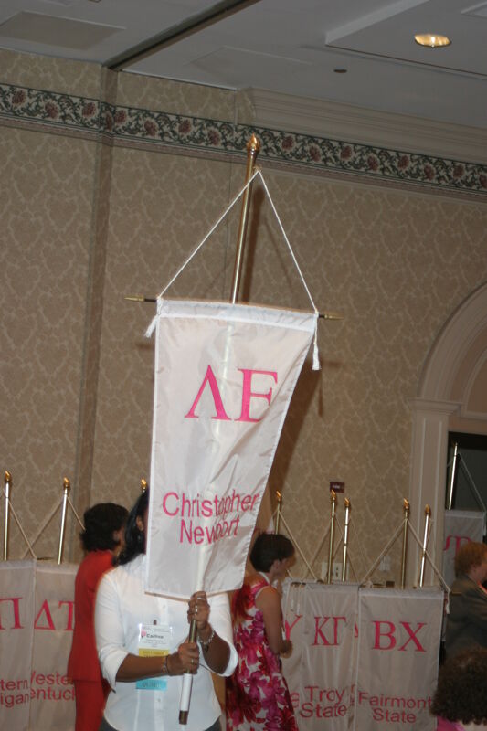 Carlina Figueroa With Lambda Epsilon Chapter Banner in Convention Parade of Flags Photograph, July 9, 2004 (Image)