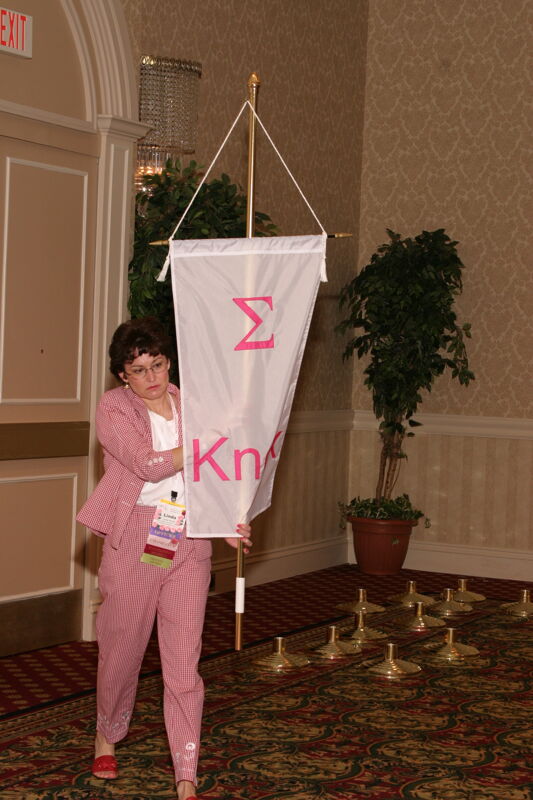 Linda Riouff With Sigma Chapter Banner in Convention Parade of Flags Photograph, July 9, 2004 (Image)
