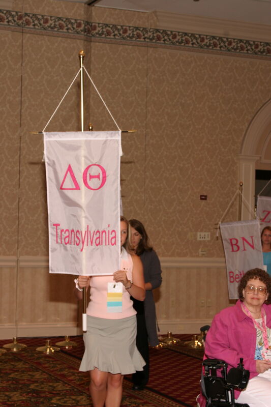 Unidentified Phi Mu With Delta Theta Chapter Banner in Convention Parade of Flags Photograph, July 9, 2004 (Image)