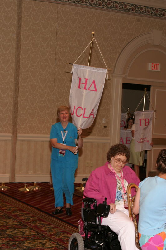 Unidentified Phi Mu With Eta Delta Chapter Banner in Convention Parade of Flags Photograph, July 9, 2004 (Image)