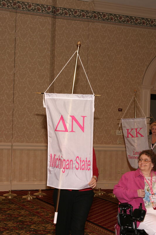 Unidentified Phi Mu With Delta Nu Chapter Banner in Convention Parade of Flags Photograph, July 9, 2004 (Image)
