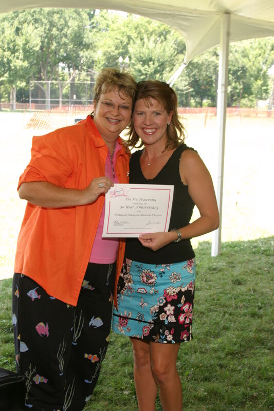 Kathy Williams and Northeast Arkansas Alumna With Certificate at Convention Outdoor Luncheon Photograph 2, July 10, 2004 (Image)