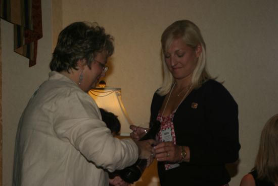 Kathy Williams Pouring a Drink for Kris Bridges at Convention Officers' Party Photograph, July 7, 2004 (image)