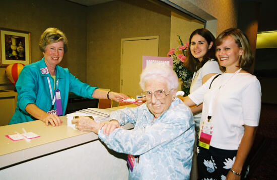 Stone, Hughes, and Two Unidentified Phi Mus at Convention Registration Desk Photograph, July 4-8, 2002 (image)