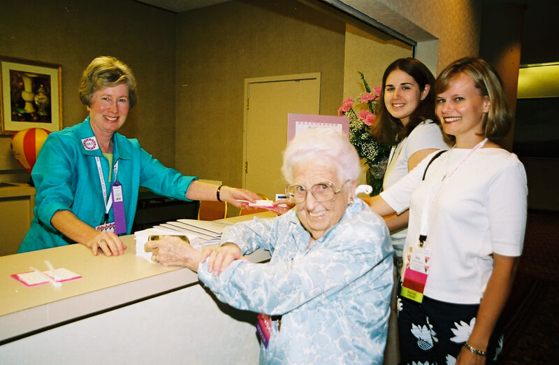 Stone, Hughes, and Two Unidentified Phi Mus at Convention Registration Desk Photograph, July 4-8, 2002 (Image)