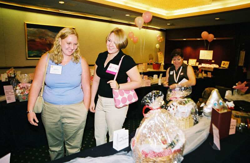 McNamara, Alford, and Unidentified in Convention Gift Basket Display Photograph 2, July 4-8, 2002 (Image)