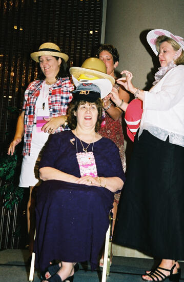 Cathy Moore Placing Hat on Mary Jane Johnson at Convention Officers' Luncheon Photograph, July 4-8, 2002 (image)